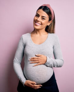 Pregnant woman holding belly.